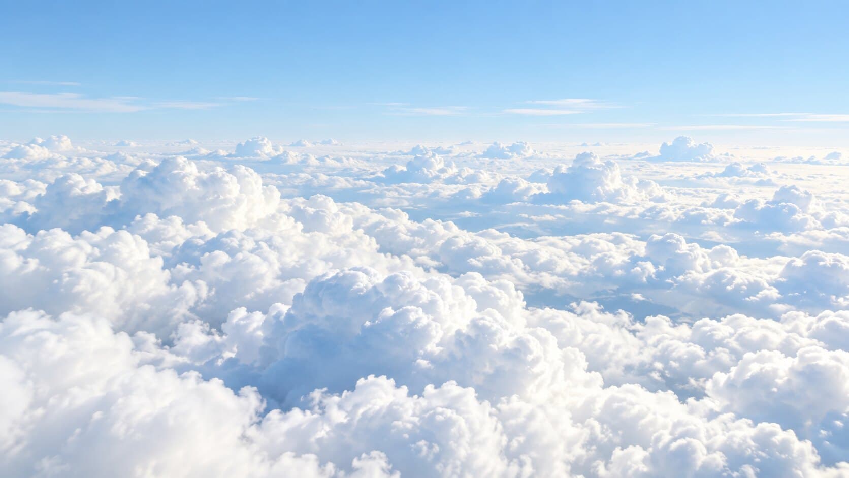 An endless sea of white clouds under a pale blue sky